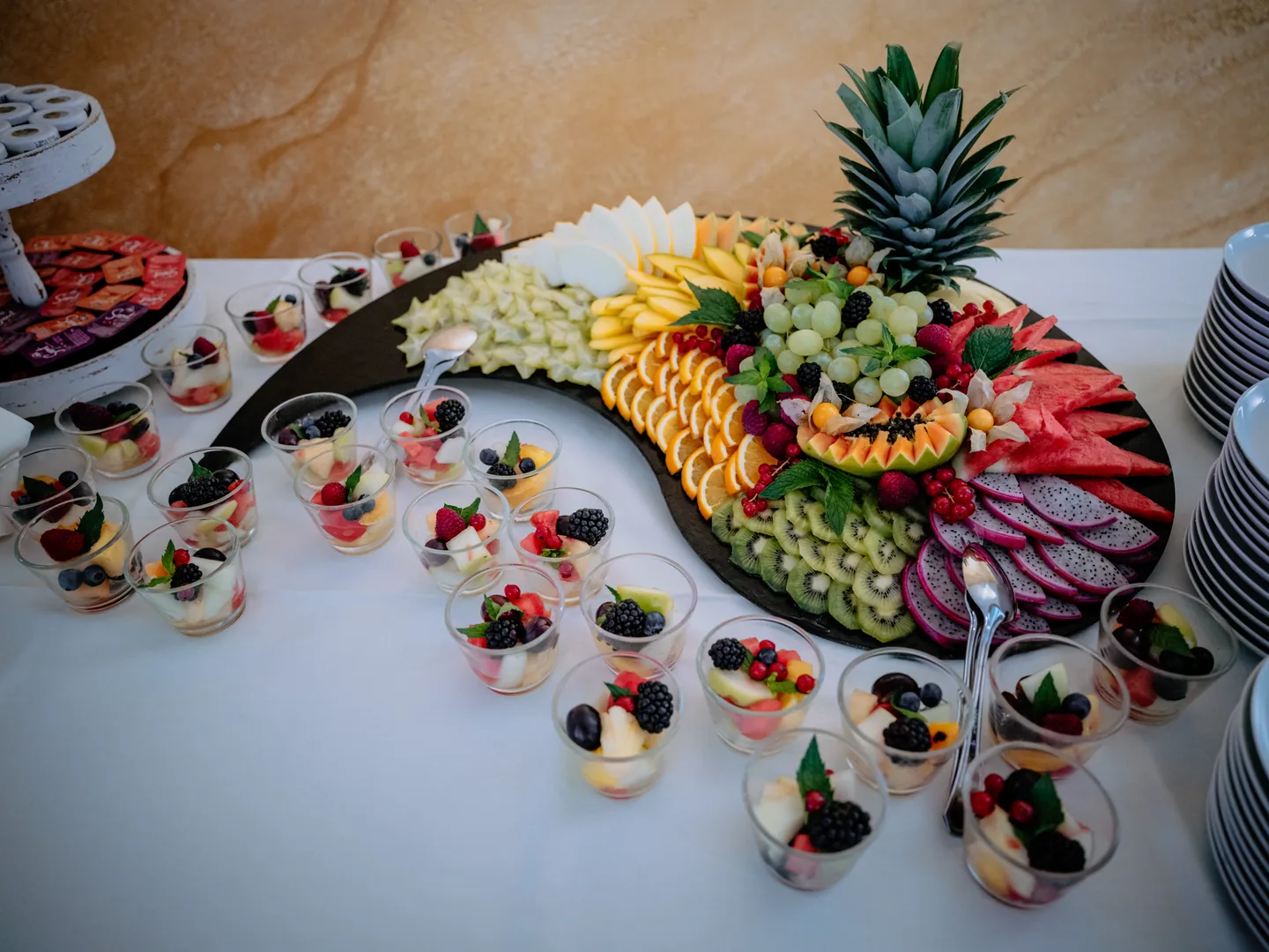 Frische Früchte mit Ananas, Melone und Beeren sowie kleine Dessertgläser