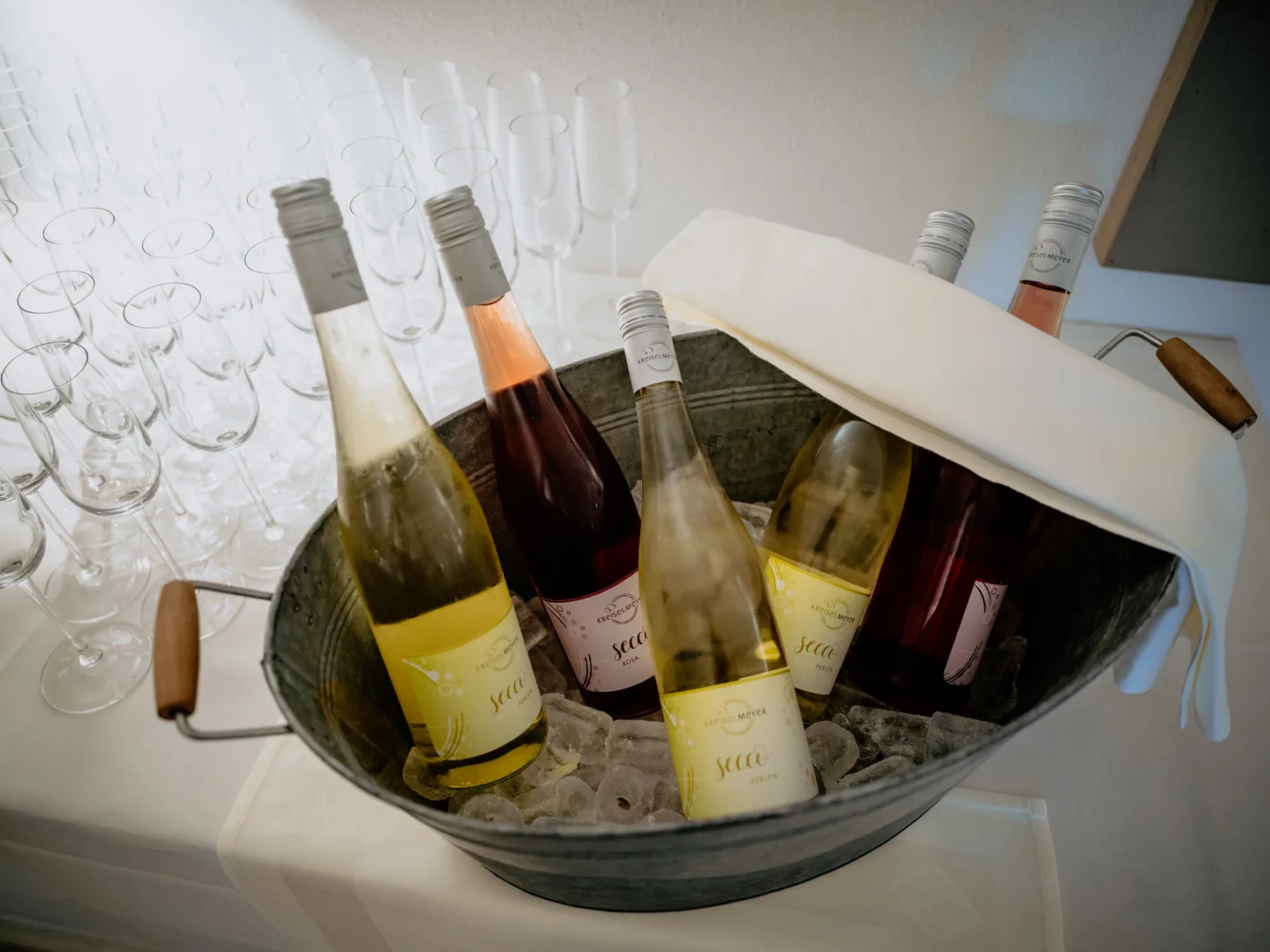 Gekühlter weißer und Rosé-Secco auf Eis mit bereitgestellten Sektgläsern beim Schlossbrunch