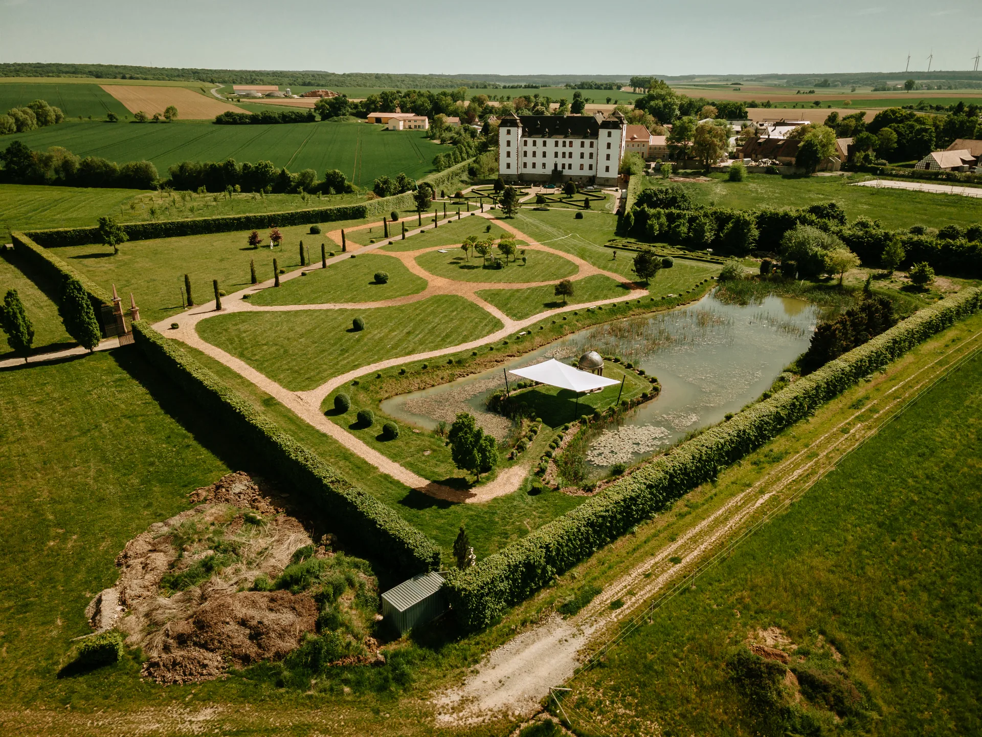 Luftbild von Schloss, Park und Seeinsel mit Sonnensegel