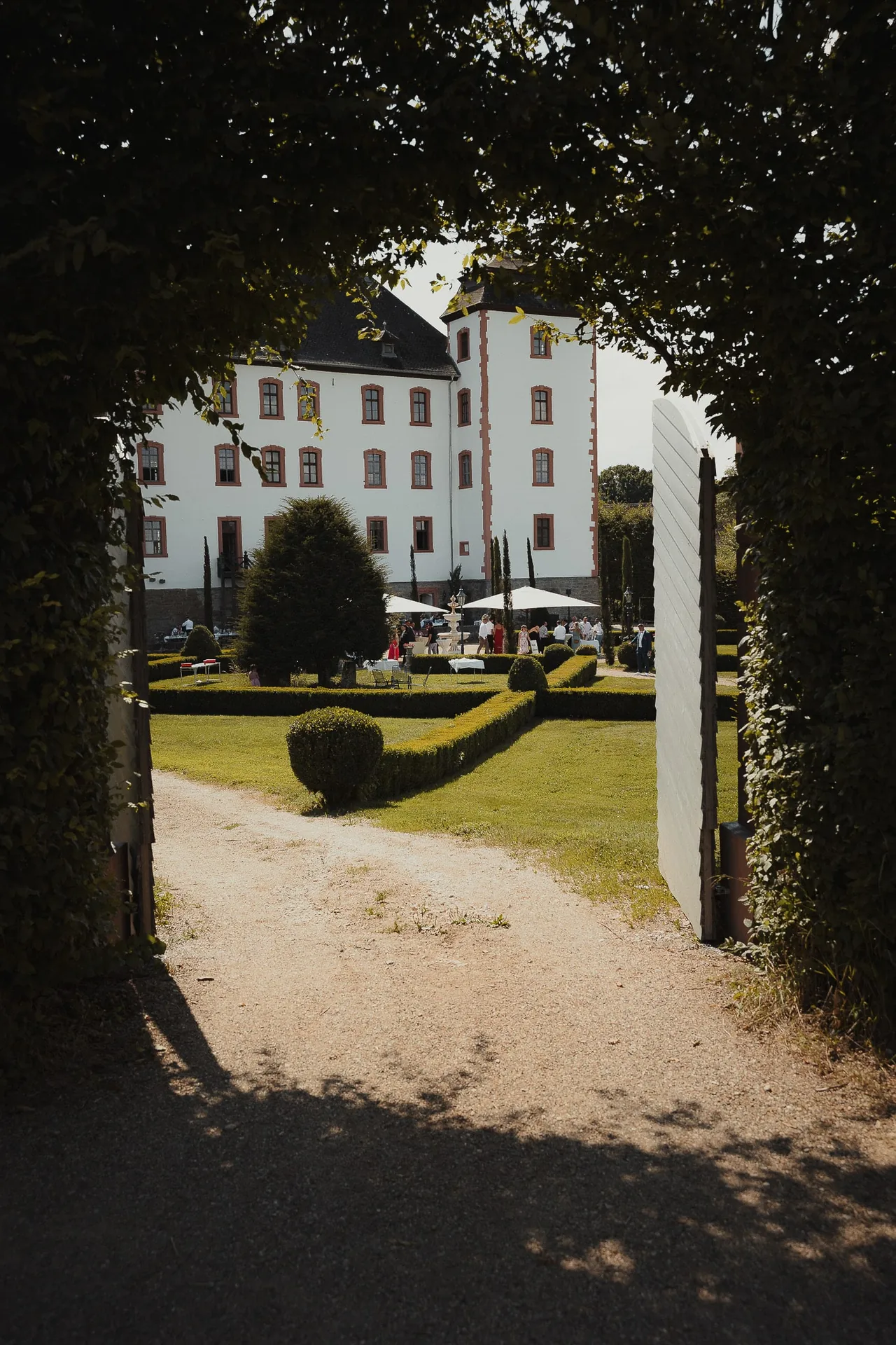 Gäste beim Empfang im Parkgarten vor der Schlossfassade