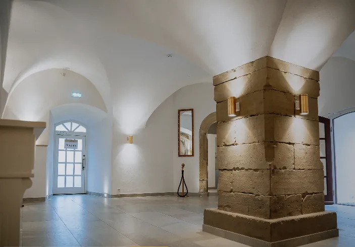 Foyer mit Kreuzgewölbe, Natursteinpfeiler und Tageslicht am Eingang
