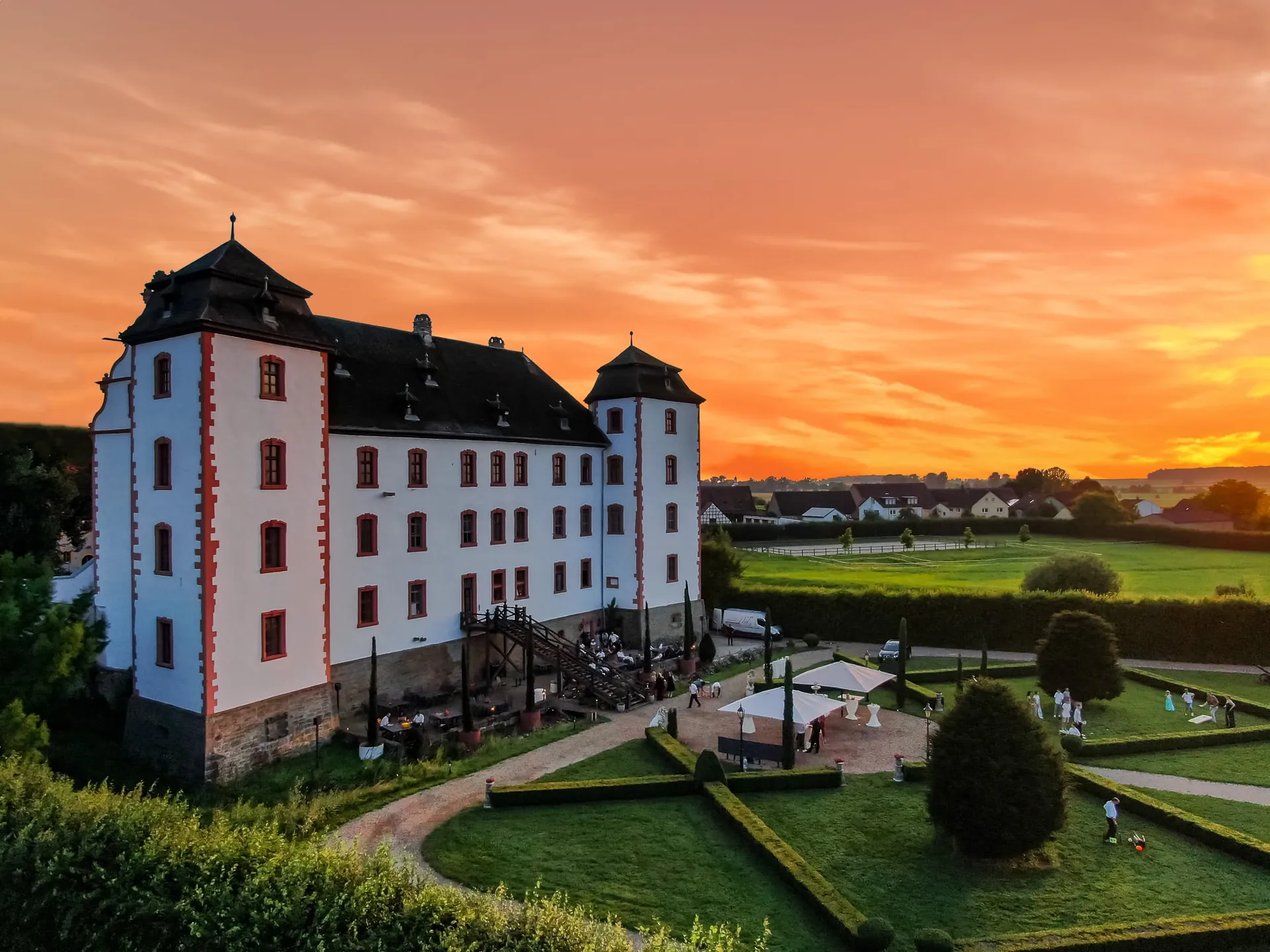 Schlossfassade und Schlosspark im Abendlicht