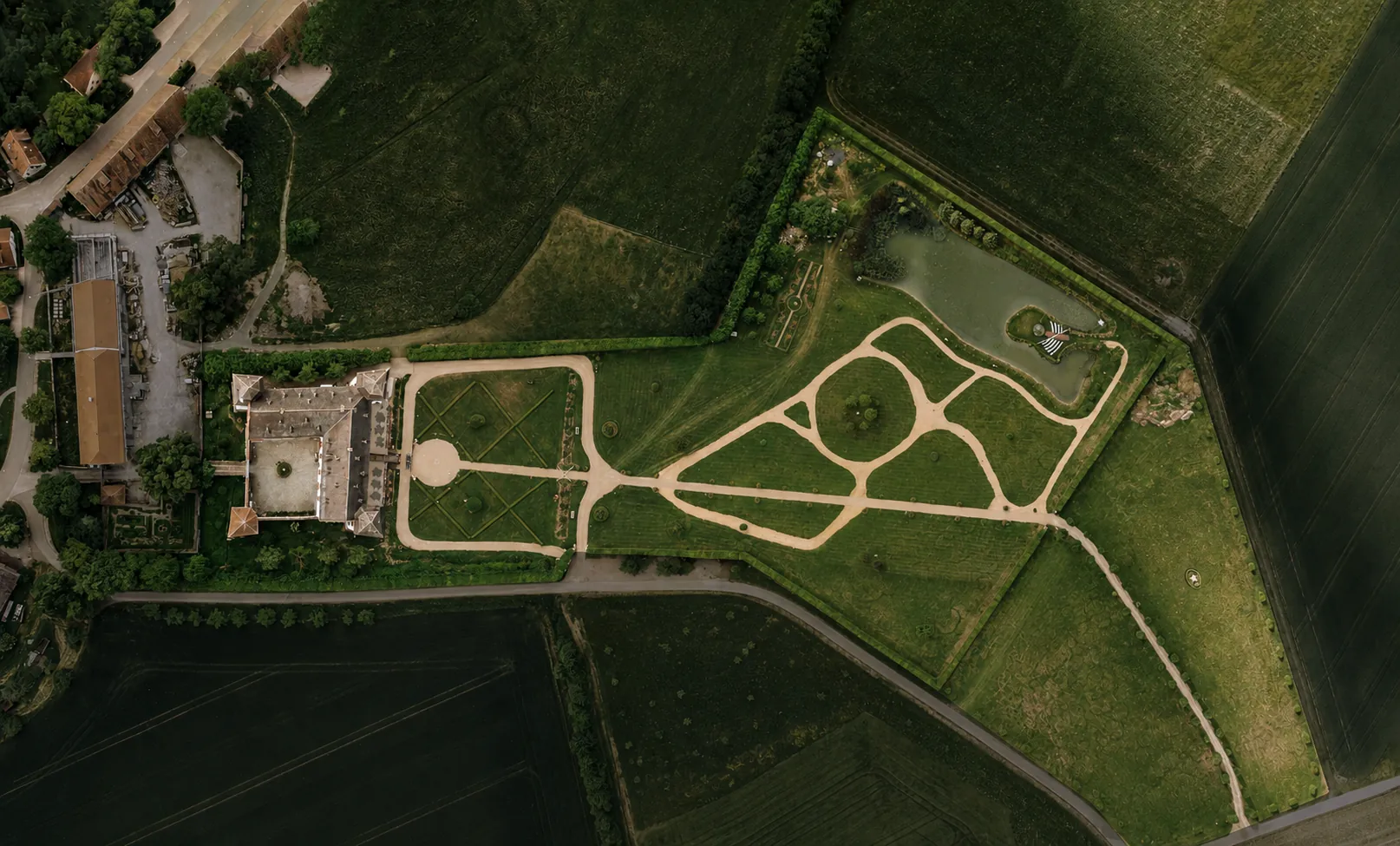 Luftaufnahme von Schloss Walkershofen mit Schlosshof, Parkgarten, Rundwegen und See