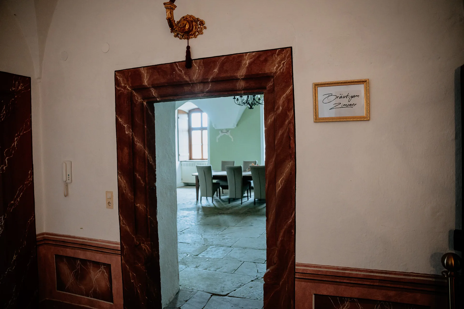 Marmorierter Türrahmen mit Schild Bräutigamzimmer, Blick in den grünen Gewölberaum